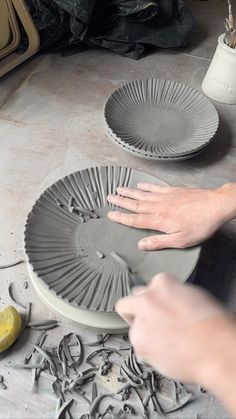 two plates being made on the floor by someone's hands