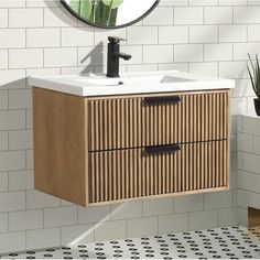 a bathroom vanity with two drawers and a mirror on the wall next to tiled walls