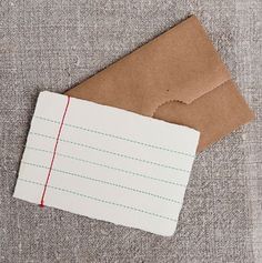 a piece of brown paper sitting on top of a table next to a white envelope