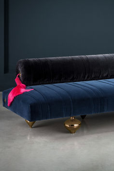 a blue velvet bench with pink tassels on it