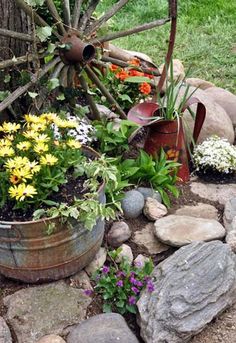 a garden with rocks, flowers and an old wagon