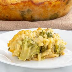 broccoli and macaroni casserole on a white plate next to a loaf of bread