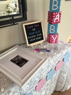 a baby shower sign and photo frame on a table