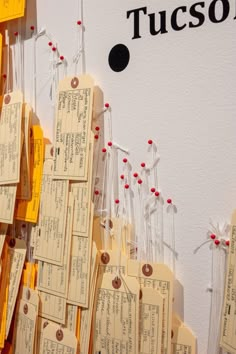 several pieces of paper with tags attached to them on a white wall that says tuson