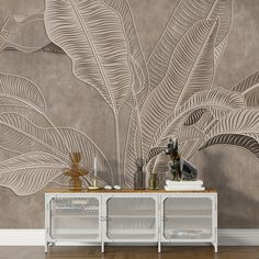 a wall with a plant on it next to two white sideboards and a vase