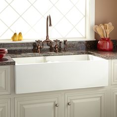 a kitchen sink with two faucets on the side and marble counter tops in front