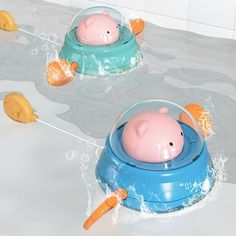 two toys are floating in the water on top of each other, one piggy bank