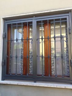 a window with iron bars and wooden windowsills on the side of a building