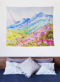 a painting hanging on the wall above a bed