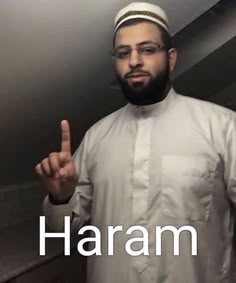 a man with glasses and a beard standing in front of a mirror giving the peace sign