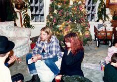 a group of people sitting around a christmas tree