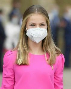 a woman wearing a face mask while walking down the street