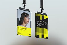 two black and yellow id cards hanging from hooks with lanyards attached to them