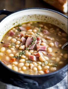 a close up of a bowl of soup with ham and beans in it on a table