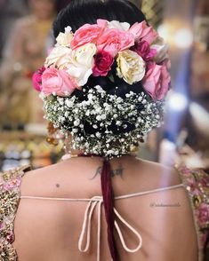 the back of a woman's head with flowers in her hair