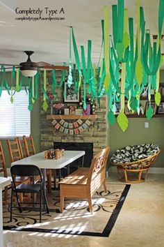 a dining room filled with lots of furniture and hanging paper streamers above the table