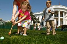 a woman and two children playing golf in front of the white house