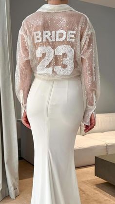 a woman in a white wedding dress with the number 29 on it's back