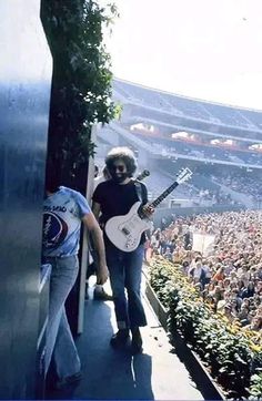 two men are playing guitars in front of an audience