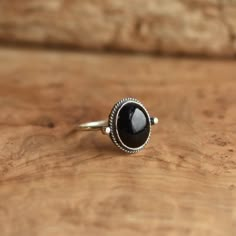 *LBJ is moving this week to a new studio in Baltimore! There may be a slight delay in your order by a day or so while we get settled* This is a perfect dainty black ring - .925 Sterling Silver - Black Onyx Sometimes you want to gaze down at your ring and see perfect balance and grace. That's what the Delica Dainty Ring has to offer. High- grade Black Onyx with a simple, sterling silver design. Perfect little ring. Lovely, traditional, dainty ring of 10 x 12mm Black Onyx cabochon set in .925 ster Western Jewelry Rings, Piercing Places, Scorpio Ascendant, Silversmith Rings, Onyx Rings, Elopement Details, Pearl Rings Vintage, July Birthstone Ring, Black Onyx Jewelry