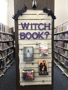 a sign that says witch book in front of bookshelves with bats on them