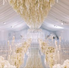 the aisle is lined with white flowers and candles