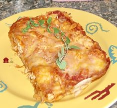 a yellow plate topped with lasagna covered in cheese