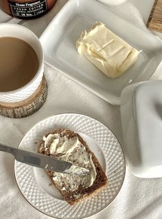 there is a piece of cake on the plate next to a cup of coffee and a knife