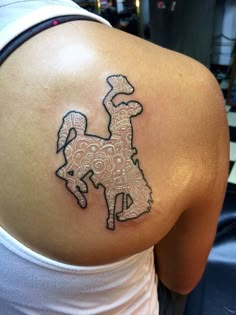 a woman with a tattoo on her back that has a horse drawn on the side