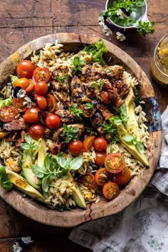 a wooden bowl filled with lots of different types of food on top of a table