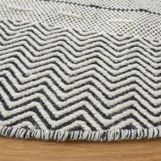 a black and white rug on top of a wooden floor