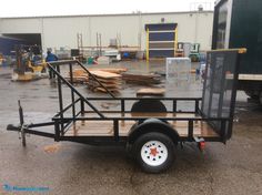 a utility trailer parked in front of a warehouse