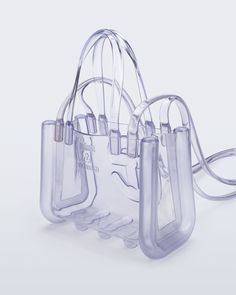 The small Melissa x Telfar Jelly Shopper — features a fluid design and tubular construction. This transparent shopper is water-resistant and concert + festival compliant, making it an instant summer staple. Molded using Melissa's exclusive Melflex materials, it looks extra bomb with the matching slides. Small is the party-bag + the afterparty too. The Afterparty, Fluid Design, Concert Festival, Summer Staples, Party Bag, Little House, Jelly, Slides, Water Resistant