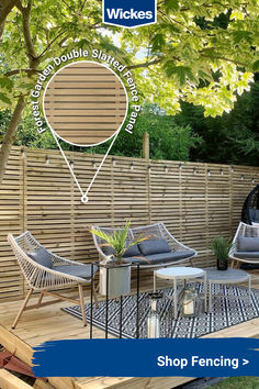 a wooden deck with two chairs and a table on it, in front of a fence