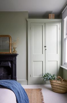 a bedroom with green walls and white cupboards