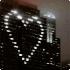 a large building with lots of lights on it's sides and windows at night