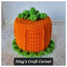 a crocheted carrot sitting on top of a white table next to a sign that says ning's craft corner