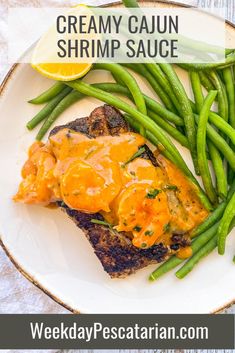 a white plate topped with fish and green beans