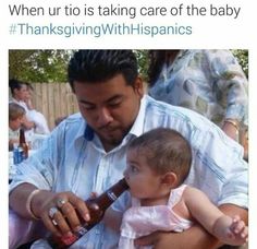 a man is holding a baby and pouring something into a bottle while others look on