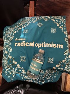 a bottle of radical optimism sitting on top of a chair