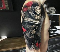 a man's arm with a skull wearing a hat and roses on it,