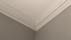 the corner of a room with a white ceiling and molding on the wall above it