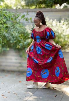 A beautiful statement dress with side pockets in a contemporary African print in a vibrant red with a bold floral pattern. It has smocking from the bust to the waist with a full skirt to the dress and adjustable exaggerated puff sleeves which can be worn off or on shoulder. An easy to wear pull on piece that may be styled for an informal outing or a formal occasion by selecting the appropriate accessories and footwear.100% Cotton. Handmade in Ghana. HAVE YOU CHECKED YOUR MEASUREMENTS AGANST THE Dress With Puff Sleeves, Maxi Skirt Dress, Statement Dress, African Design Dresses, Jumpsuit Trousers, African Design, Full Skirt, Vibrant Red, Skirt Top