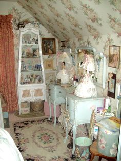 an old fashioned bedroom is decorated in pastel colors and floral wallpaper, along with antique furniture