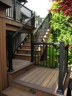 a wooden deck with black railing and handrails