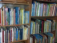 a bookshelf filled with lots of colorful books on top of wooden shelfs