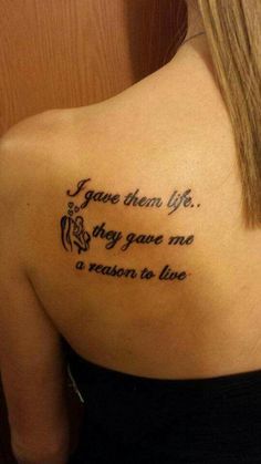 the back of a woman's shoulder with a tattoo saying, give them life