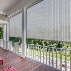 a porch with red benches and blinds on it