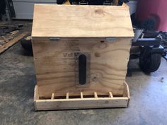 a wooden box sitting on top of a pallet in a garage next to some tools