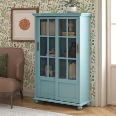 a blue bookcase in front of a wallpapered room